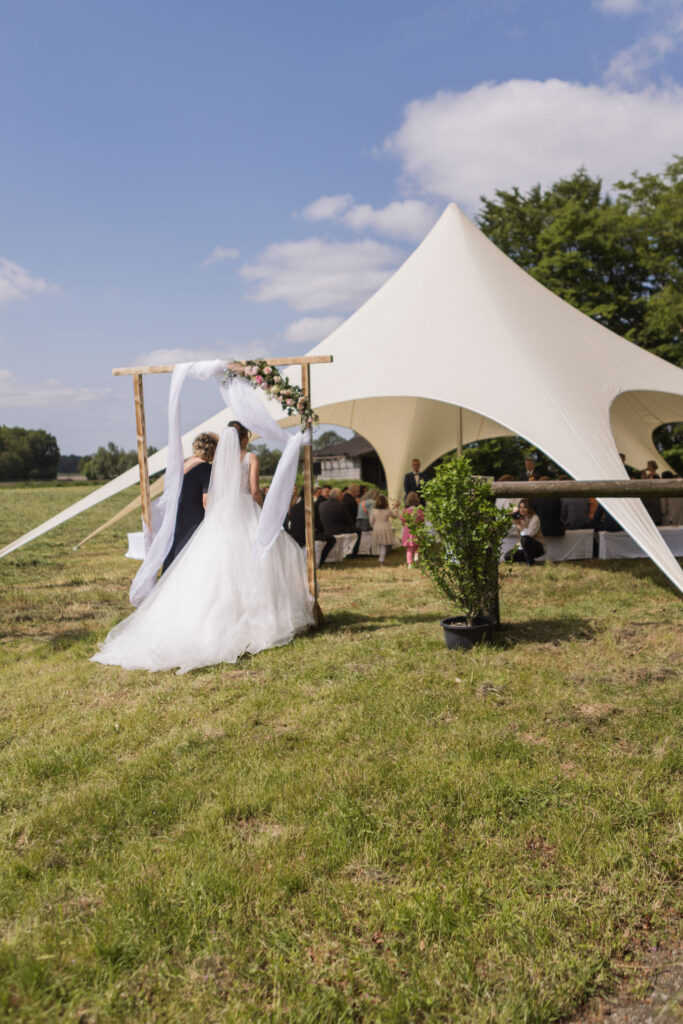 Brautpaar geht zur Trauzeremonie unter freiem Himmel