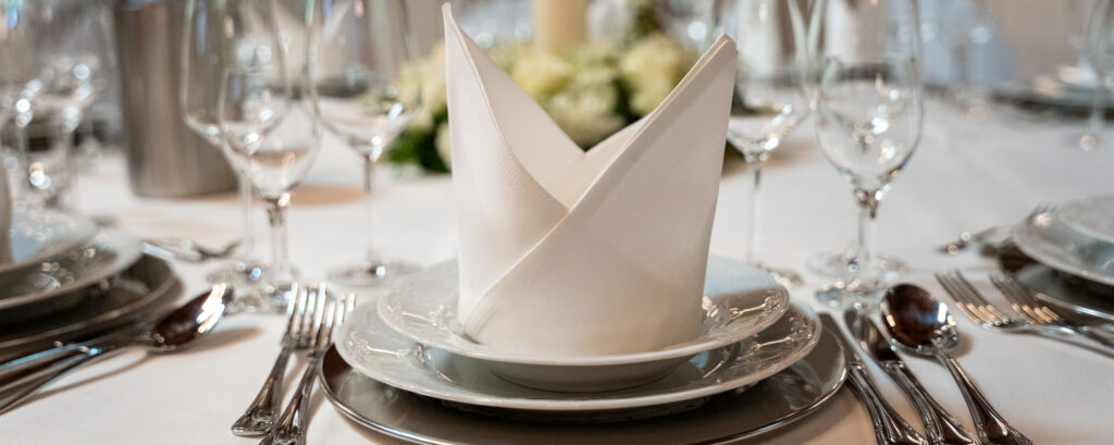 Festlich gedeckte Tafel mit Besteck, Gläsern und Servietten