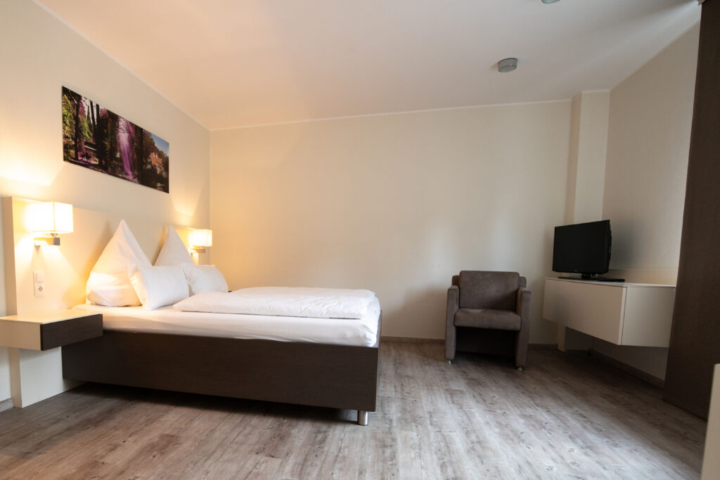 Gemütliches Hotelzimmer mit Doppelbett und Sessel