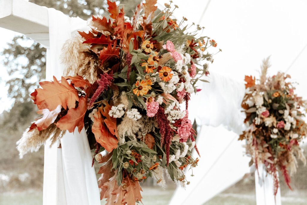 Herbstliche Hochzeitsdekoration Blumenarrangement an Pergola