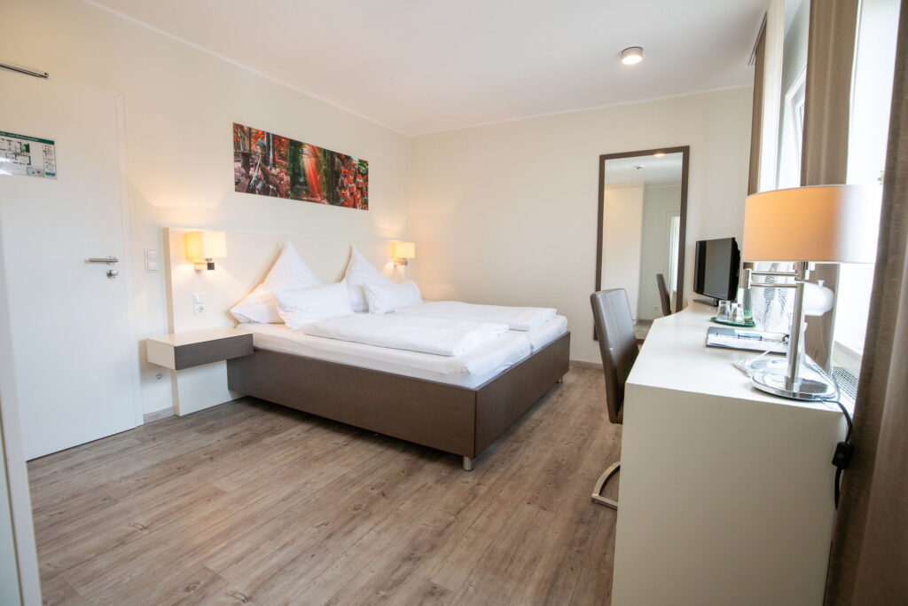 Modernes Hotelzimmer mit Doppelbett und Schreibtisch