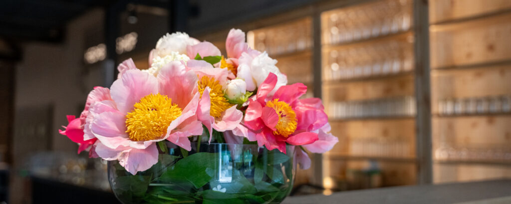 Rosa und weiße Pfingstrosen in Glasvase